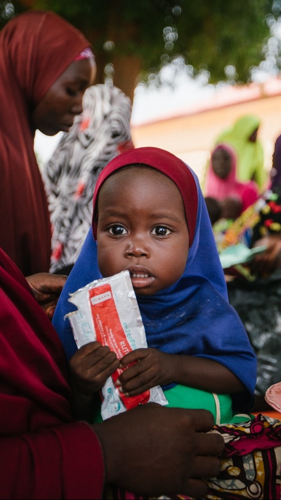 A child eats Plumpy'Nut to recover from malnutrition.