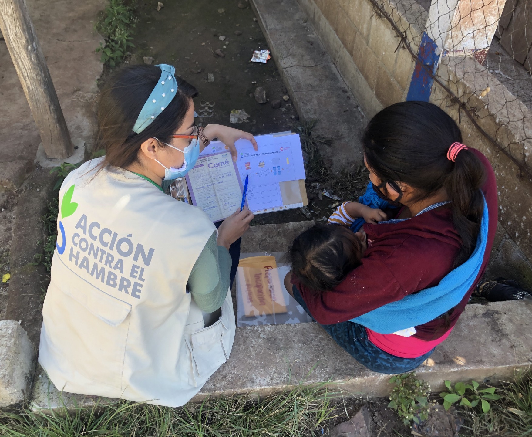 An Action Against Hunger worker helps a mother and her child.