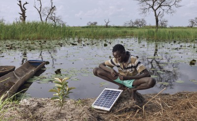 Gatwal Nhial, 9, repairs a solar panel which is their only source of power on his floating grass island in what used to be Wangkotha Village