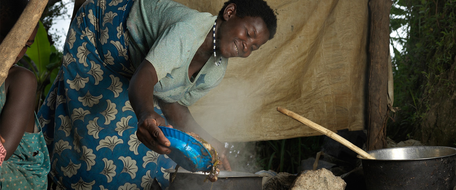 Sophia cooking for her family at home in Kanyeti village in Kasese, Uganda.