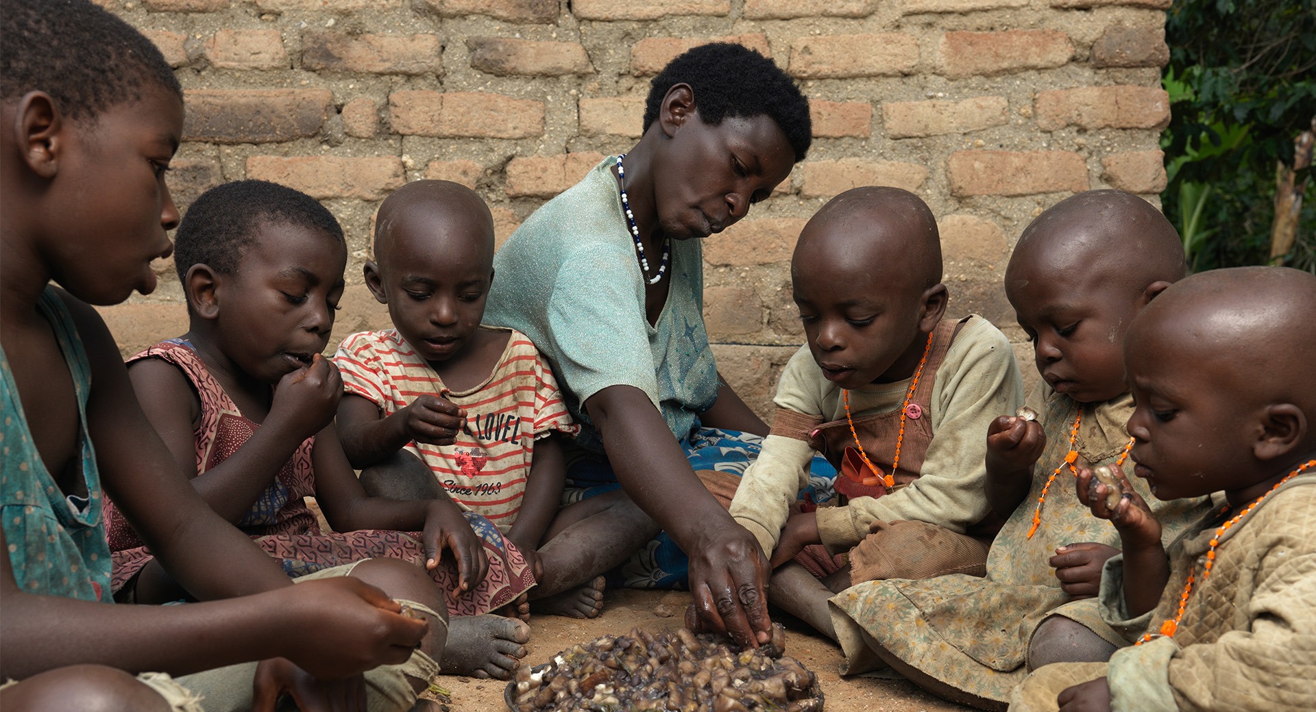 Sophia and six children gather around a plate of food.