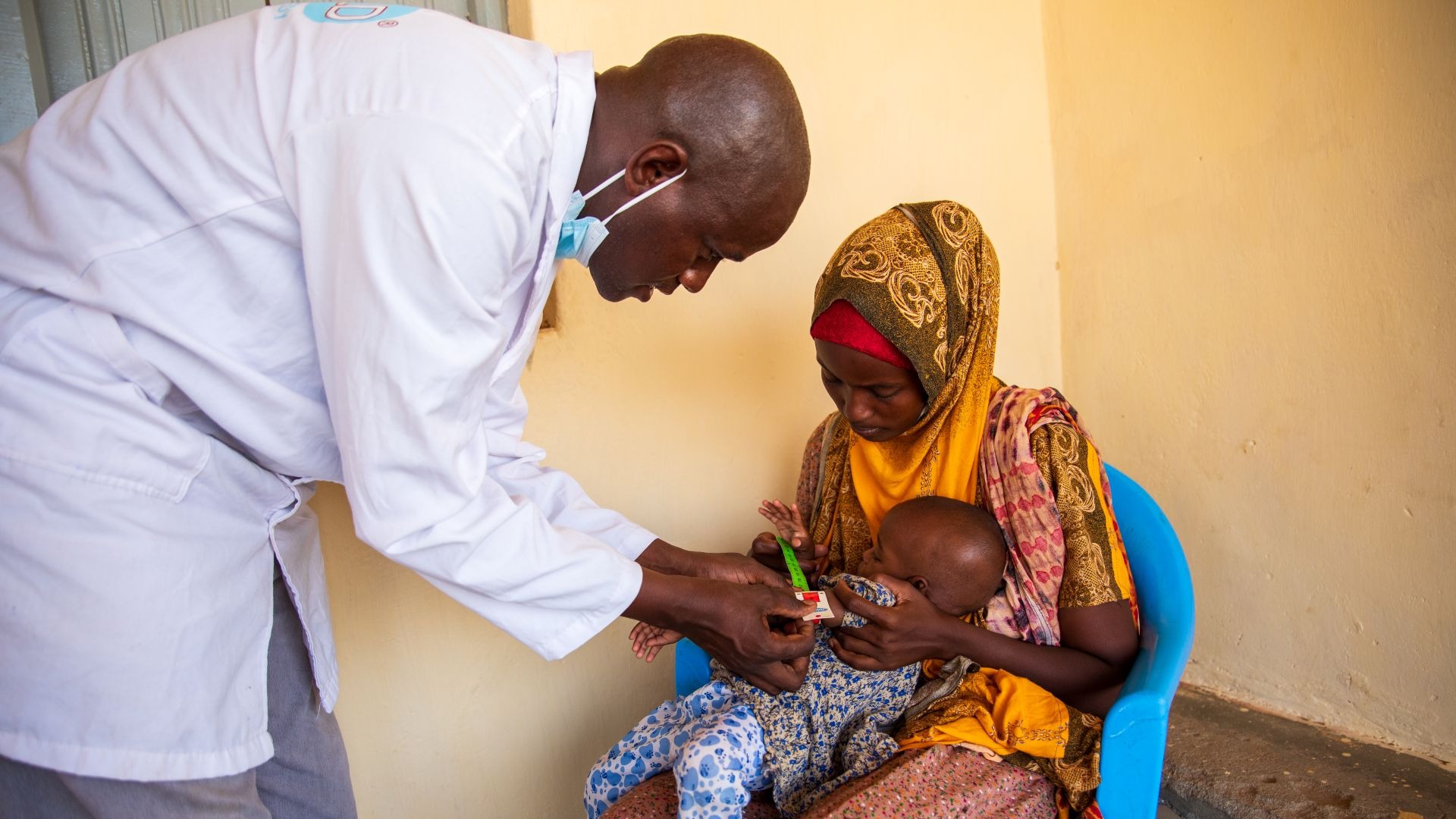 A doctor screening a child for malnutrition in Kenya.
