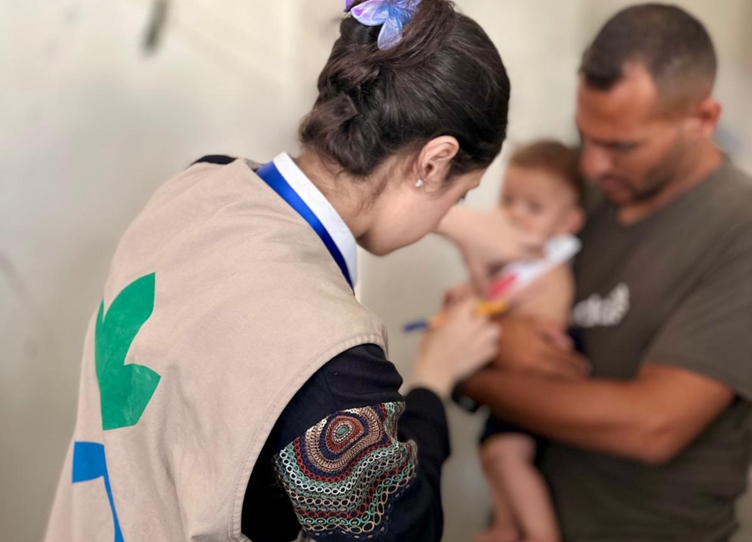 Health worker screens a child for severe malnutrition in Gaza.