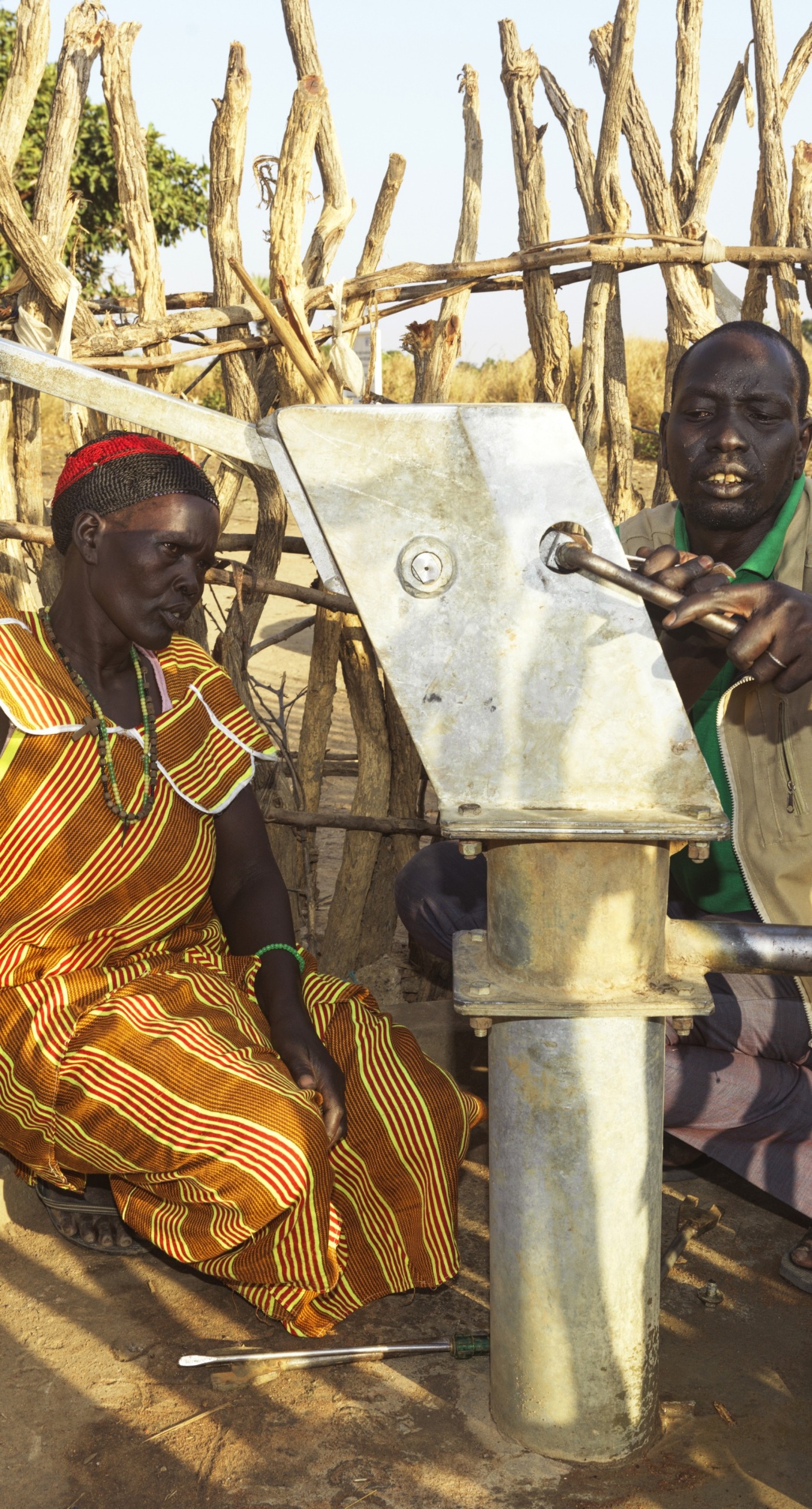 Nyanut works with a member of Action Against Hunger's team to maintain her community's borehole.
