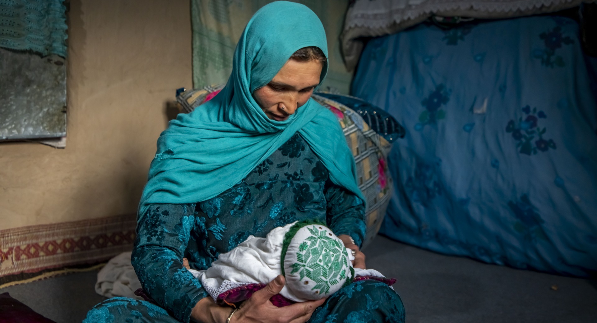 Nadia nurses her youngest child, 2 months old, at home in Duykondi Province, Afghanistan. Action Against Hunger works in this area to manage feeding programs and provide mobile health and nutrition support.