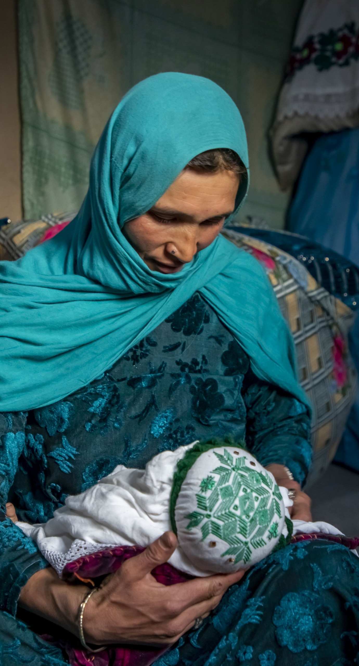 Nadia nurses her youngest child, 2 months old, at home in Duykondi Province, Afghanistan. Action Against Hunger works in this area to manage feeding programs and provide mobile health and nutrition support.