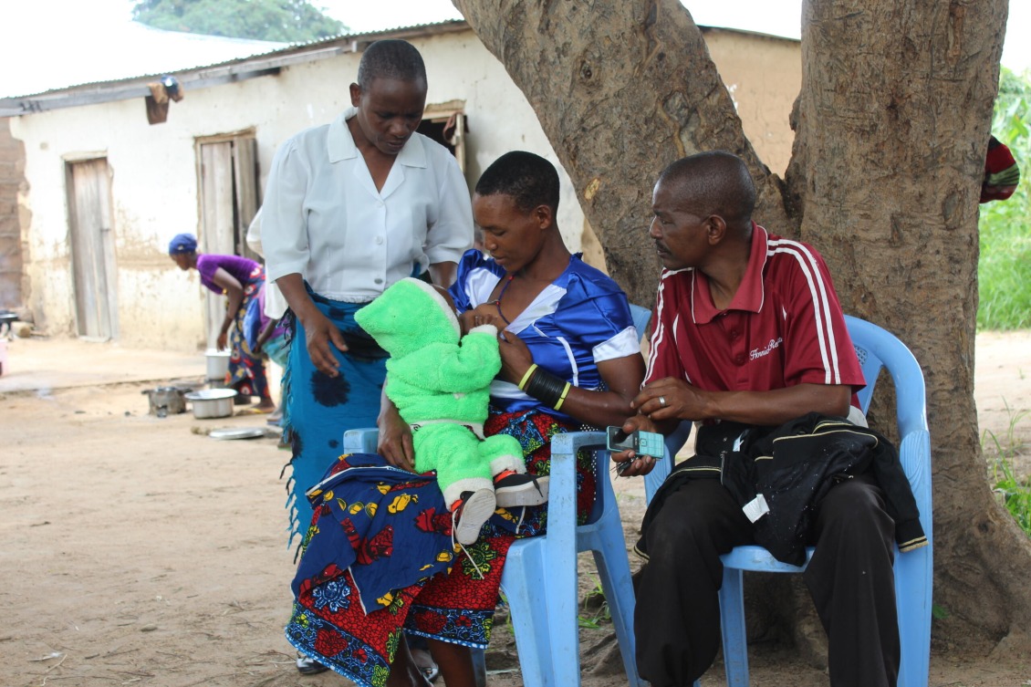 Agnes (In white), provides guidance to a breastfeeding mother in Mgandu.