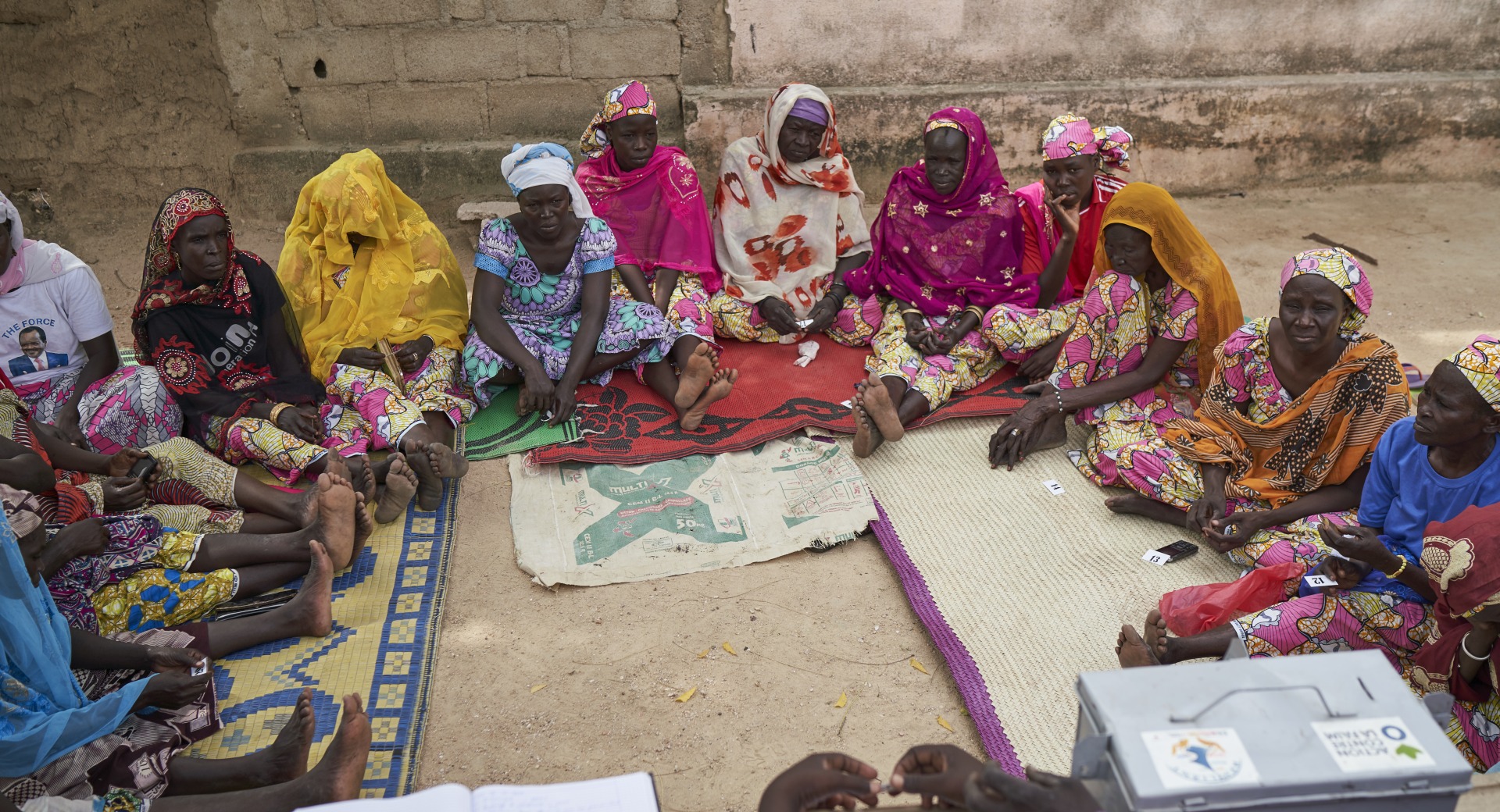 A meeting of a women's savings and loans association, where women learn to pool their resources and save for emergencies and investments.