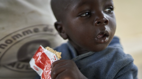 A young boy eats Plumpy'Nut, the peanut paste used to treat malnutrition.