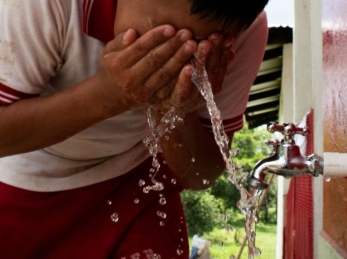 A child washing his face in Colombia.