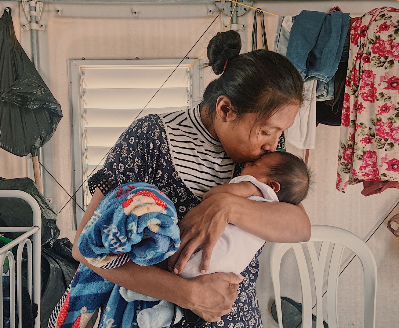 A woman holding and kissing a baby in Colombia.