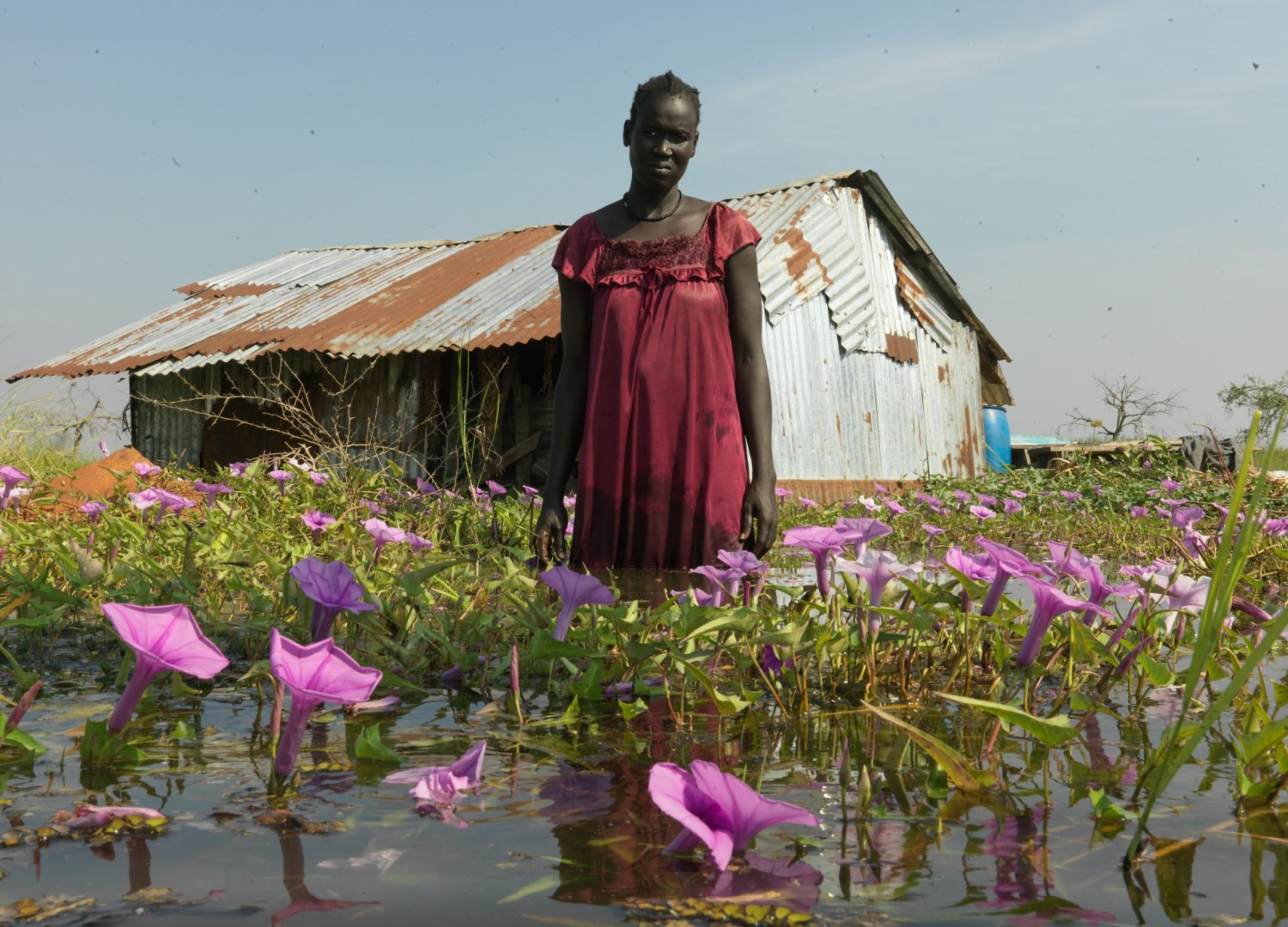 A woman standinging knee-deep flood in South Sudan.