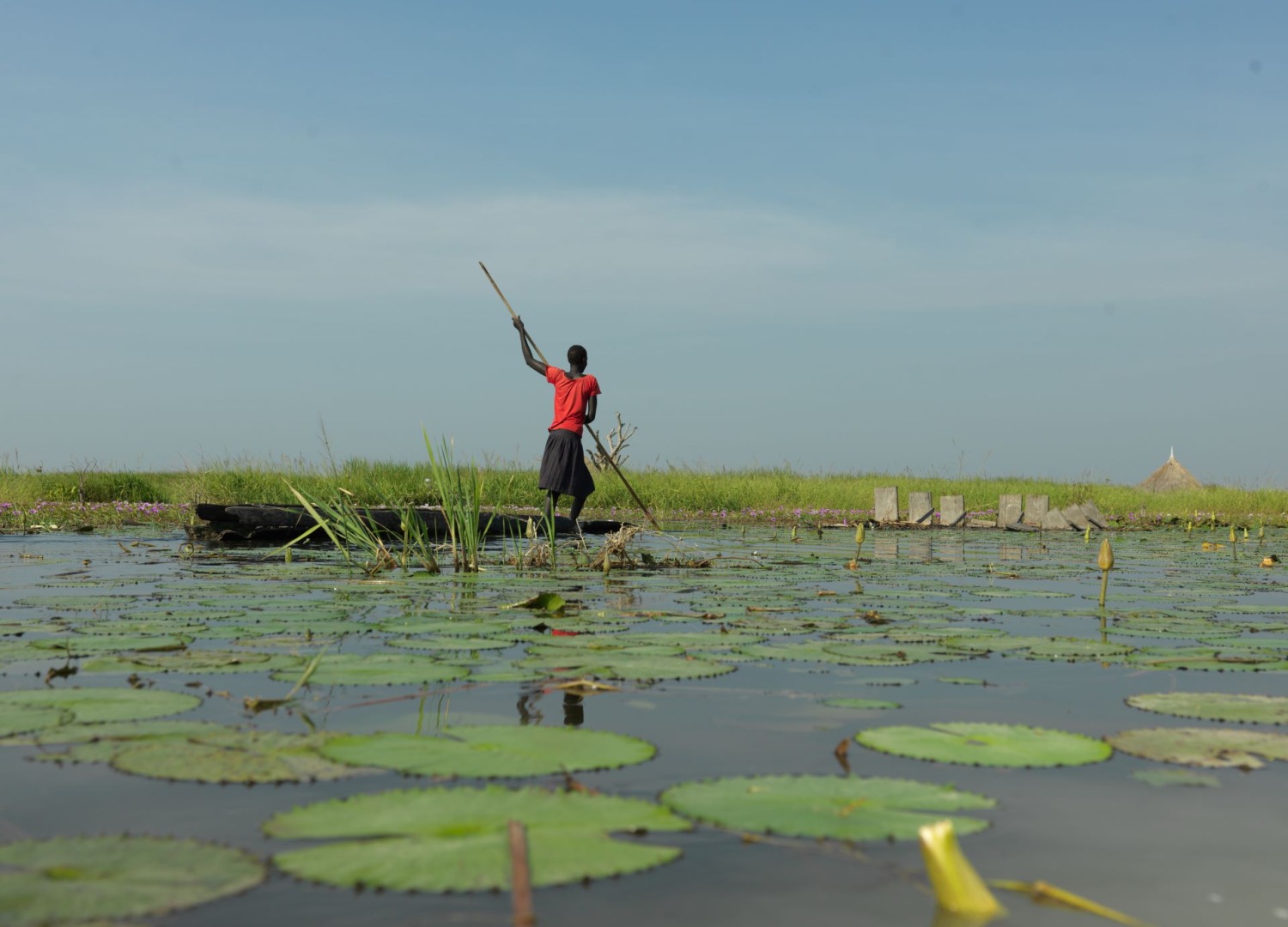 A woman rowing on a raft in South Sudan floods.