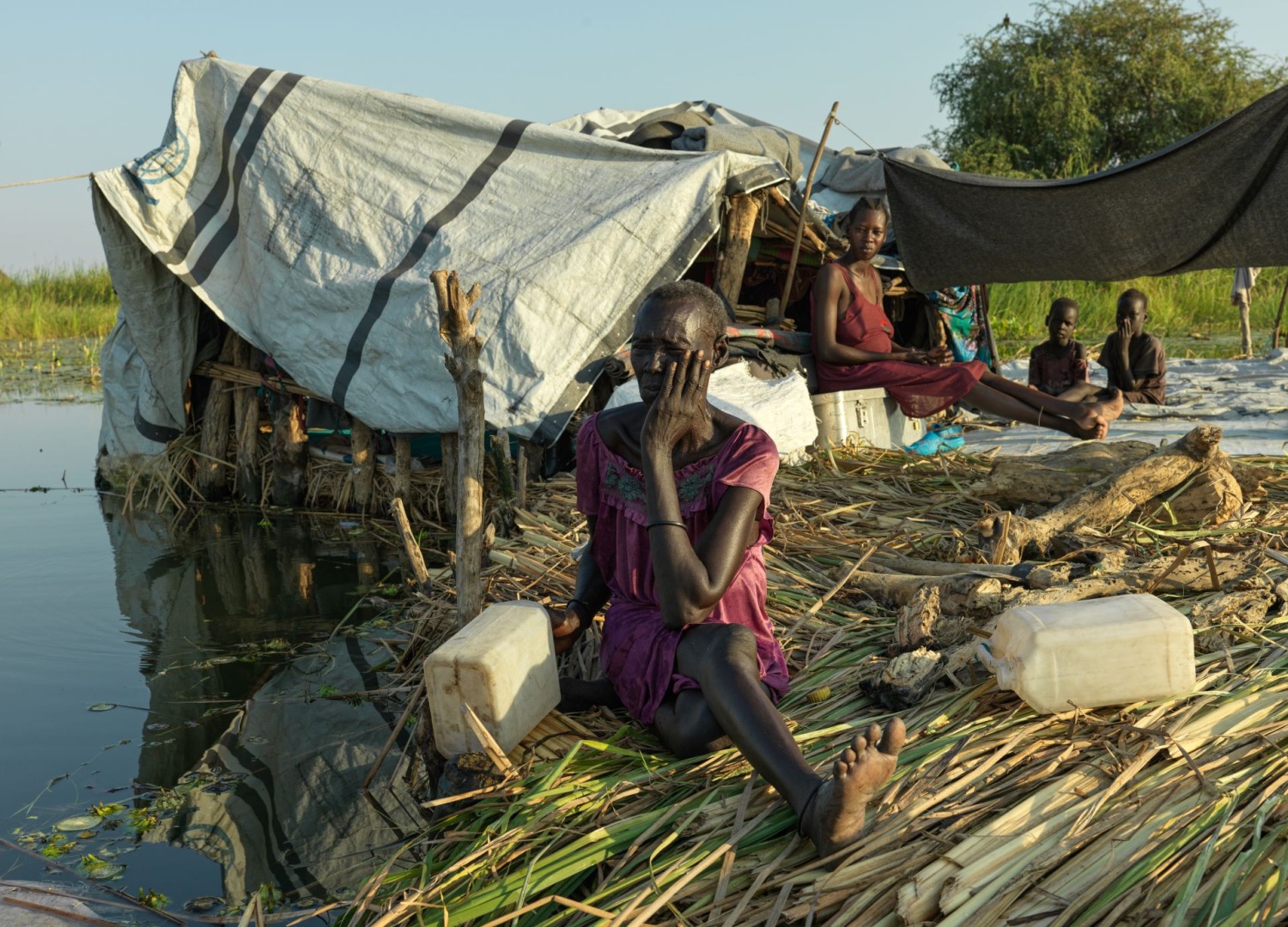 A distressed woman at home surrounded by flooding in South Sudan.