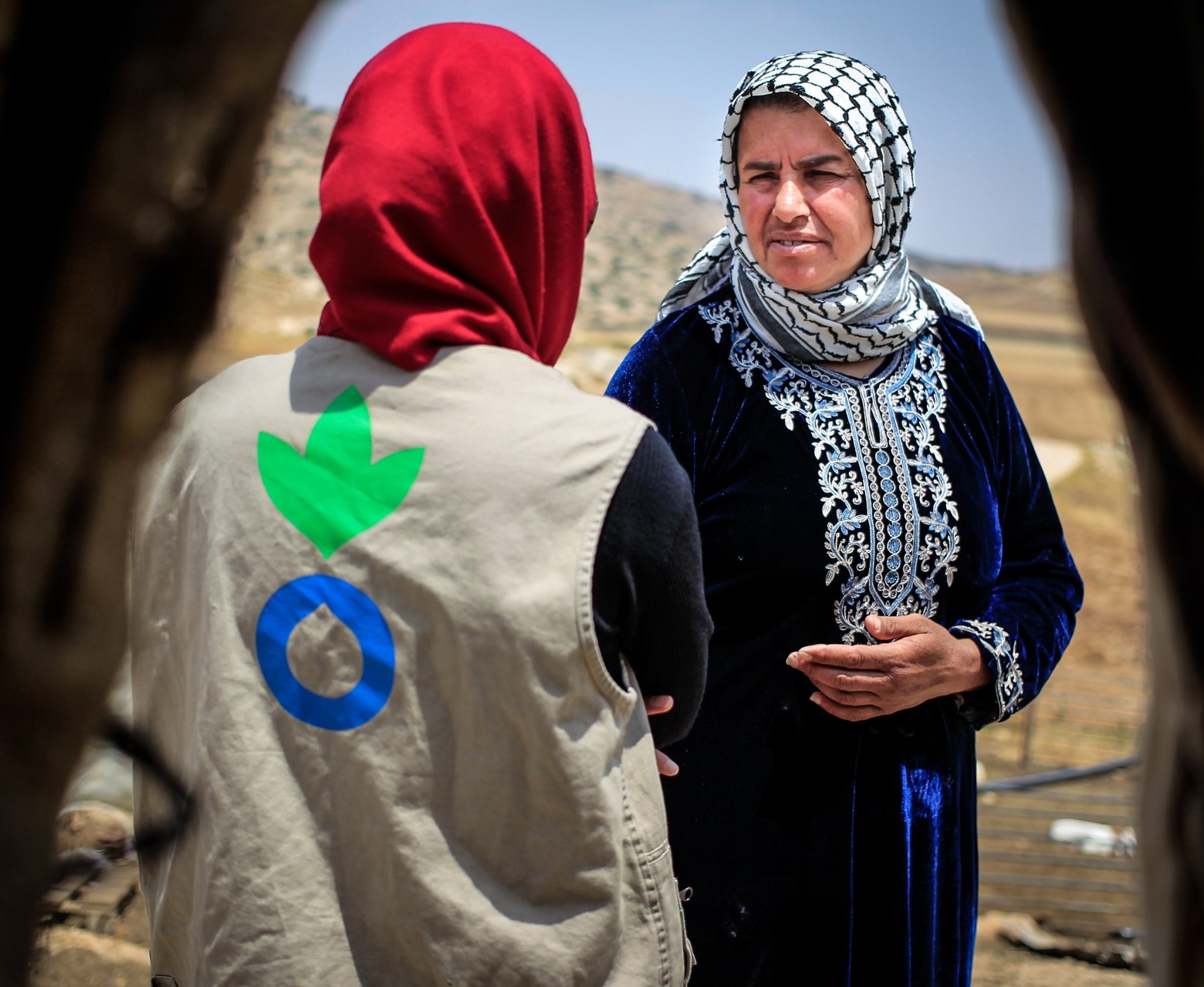 An Action Against Hunger aid worker talks with a Palestinian woman.
