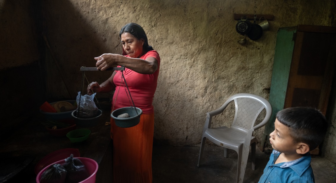 Alicia shows us in her house how she crushes the coffee beans and how she weighs them to sell them in small quantities to the neighbors.