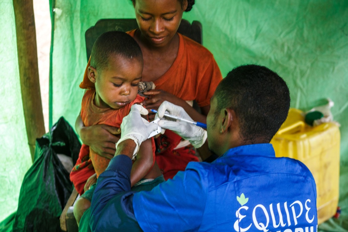 In Madagascar, an Action Against Hunger staff member uses a Mid-Upper Arm Circumference (MUAC) band to check a child for malnutrition.