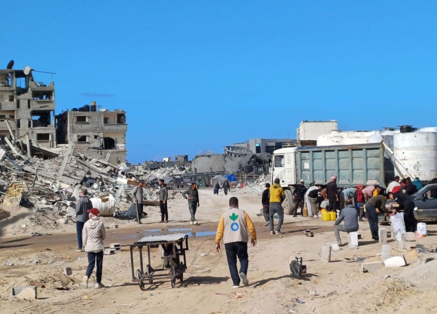 Action Against Hunger aid worker walking amidst rubble in Gaza in January 2025.