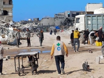 Action Against Hunger aid worker walking amidst rubble in Gaza in January 2025.