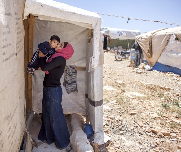 A Syrian refugee kisses her son.