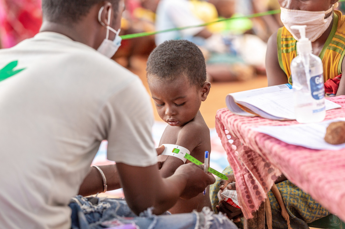 A boy is measured for malnutrition by an Action Against Hunger health worker.