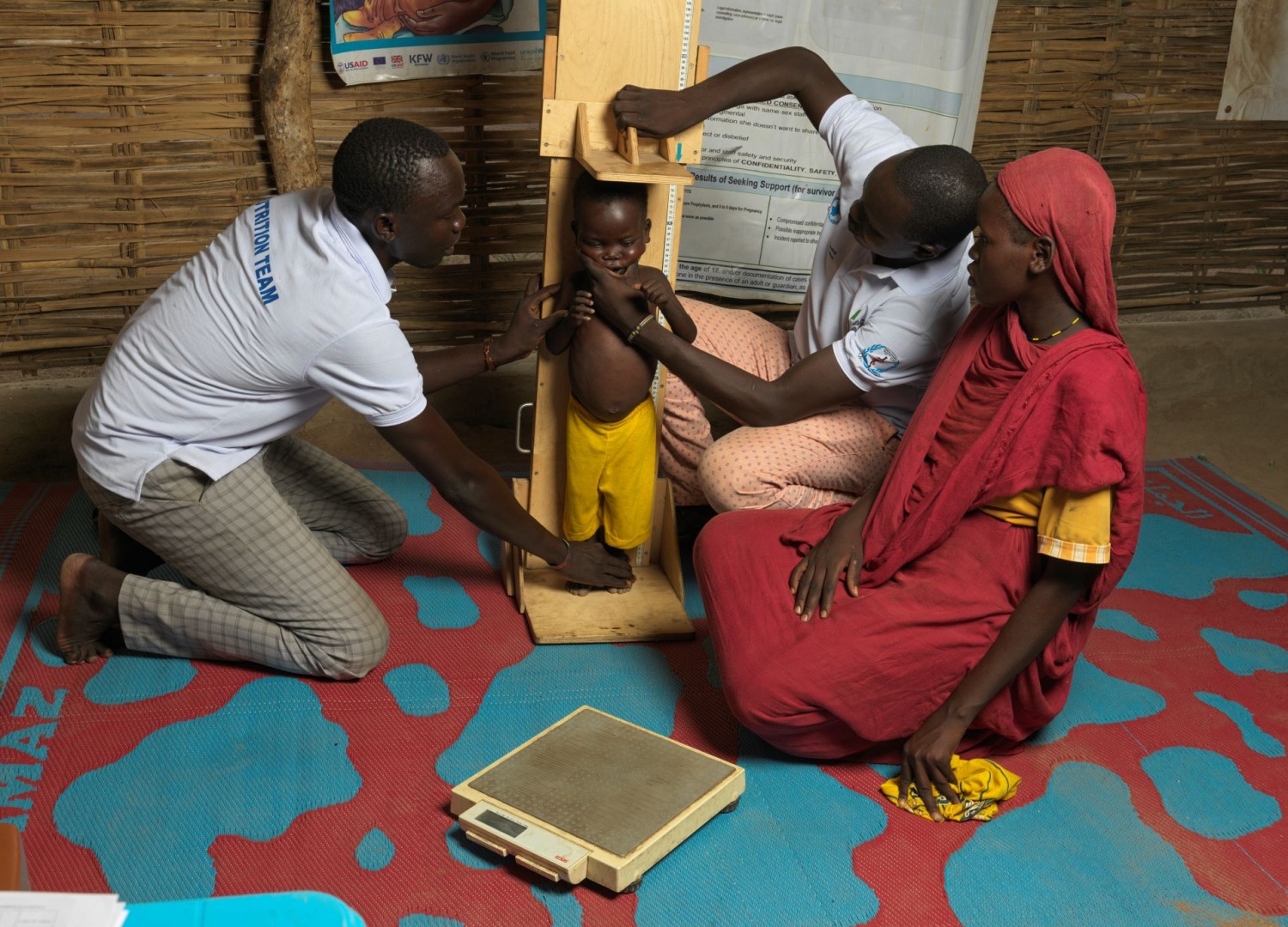Action Against Hunger community health workers measure a child's height in South Sudan.