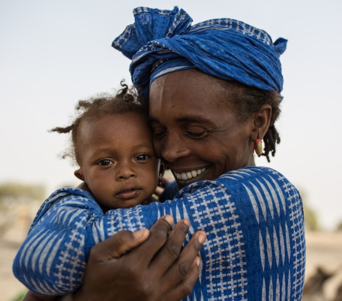 A woman hugs her daughter