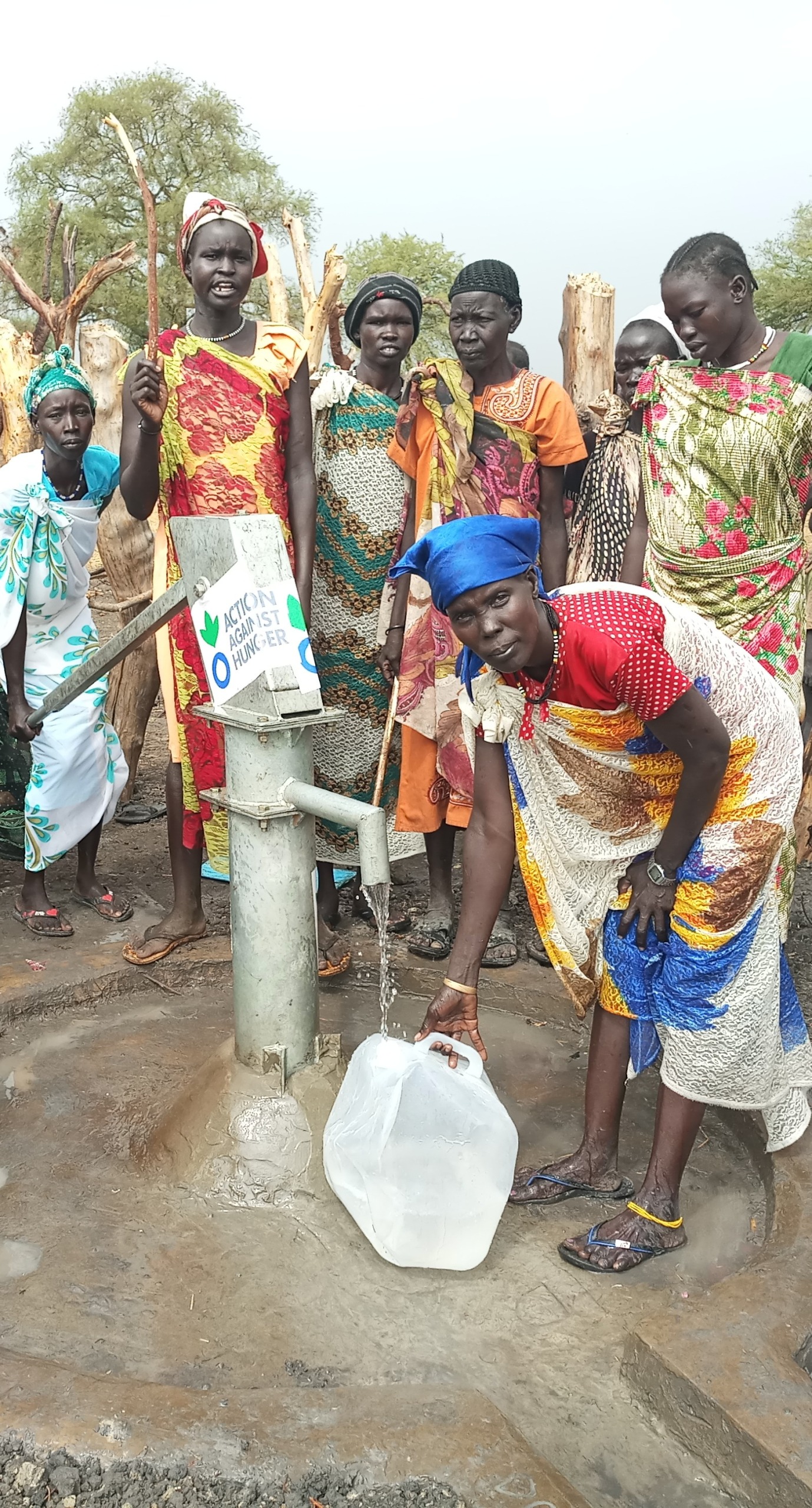 Women gather around a repaired water point in South Sudan.