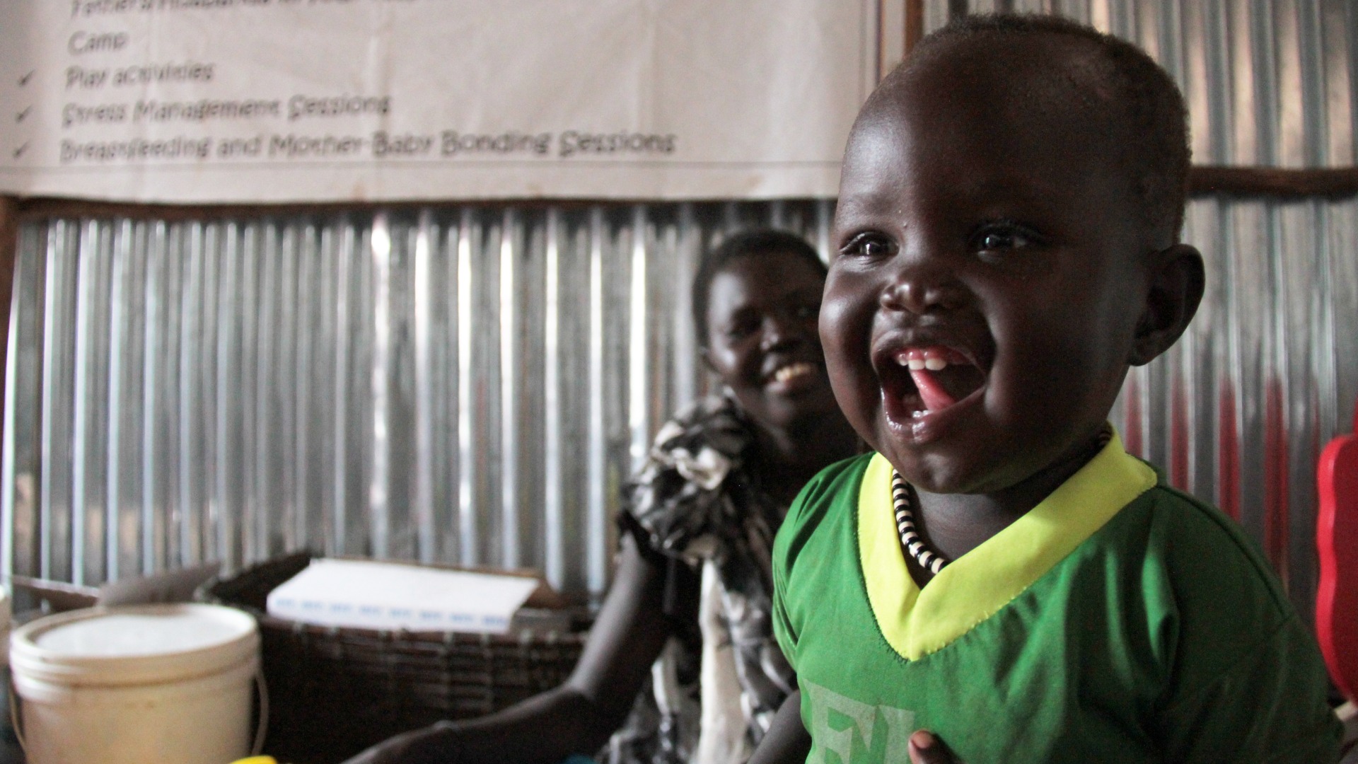 A refugee child laughs in an Action Against Hunger baby-friendly space in Ethiopia