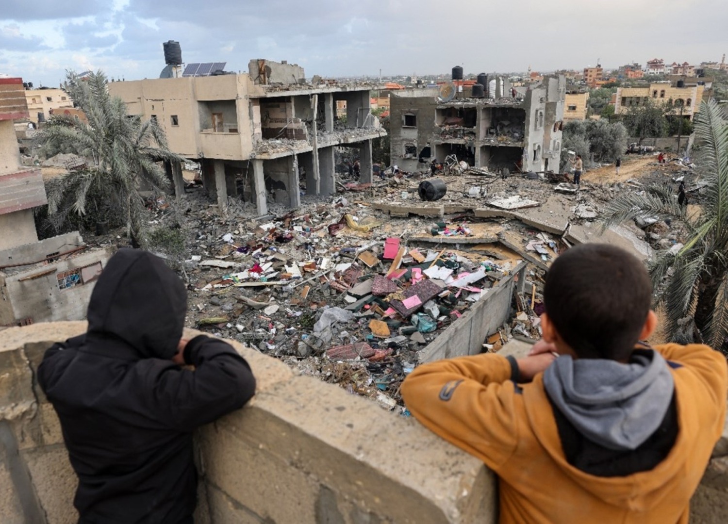 Palestinian children look at the rubble of a building destroyed during attacks in Rafah, Gaza.