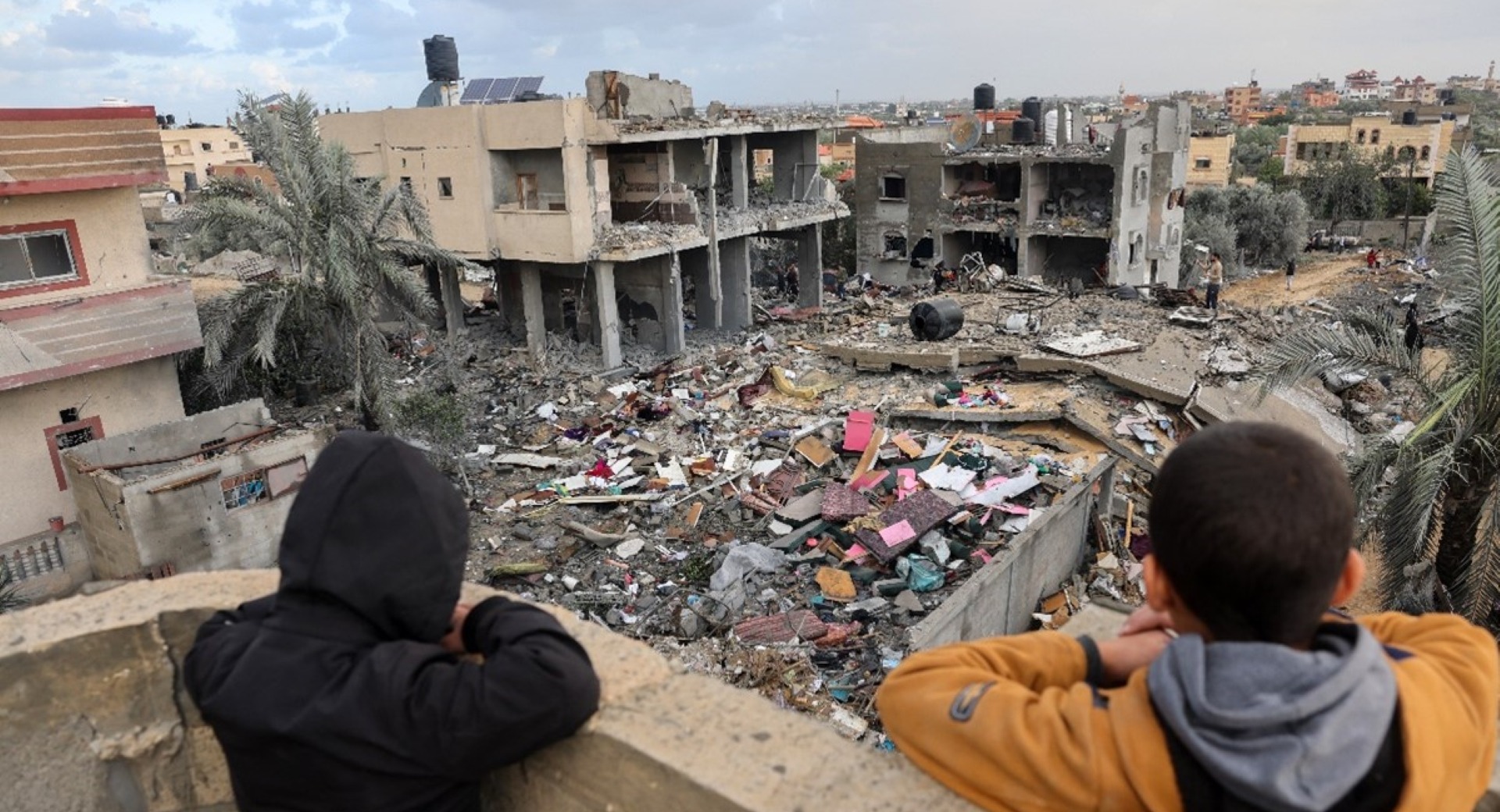 Palestinian children look at the rubble of a building destroyed during attacks in Rafah, Gaza.