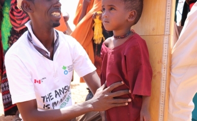 An Action Against Hunger health worker measuring the heaight and nutrition status of a child in Hudur, Somalia.