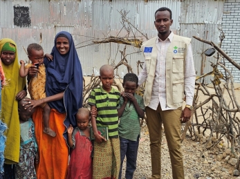 A community health worker with a woman and five children in Somalia.