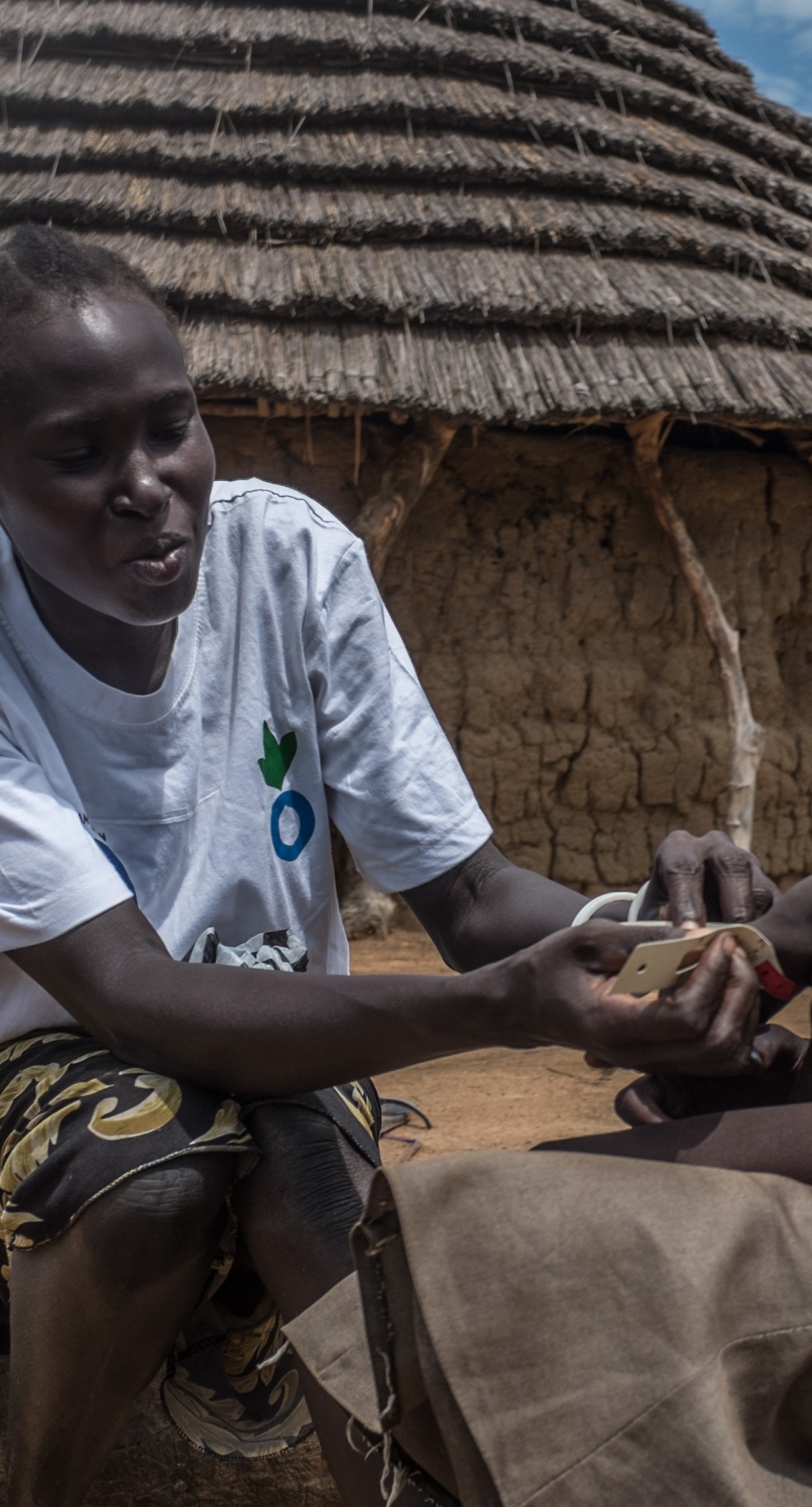 Agawol serves as an Action Against Hunger volunteer in her community. Here, she screens her neighbor's child for malnutrition.