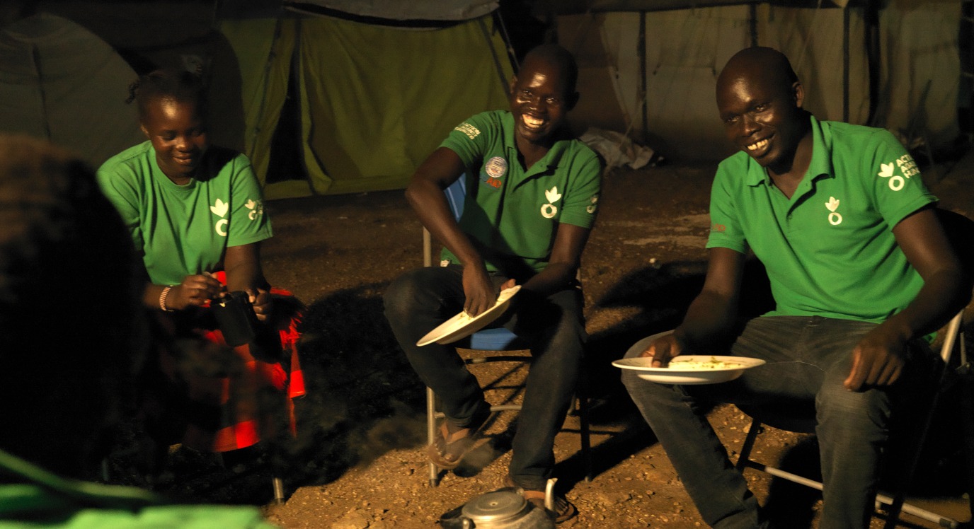 Queen and her colleagues sit and eat together at the end of a long day.
