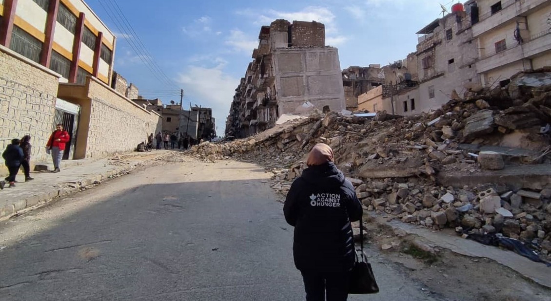 A community health worker amonst destruction in Syria.