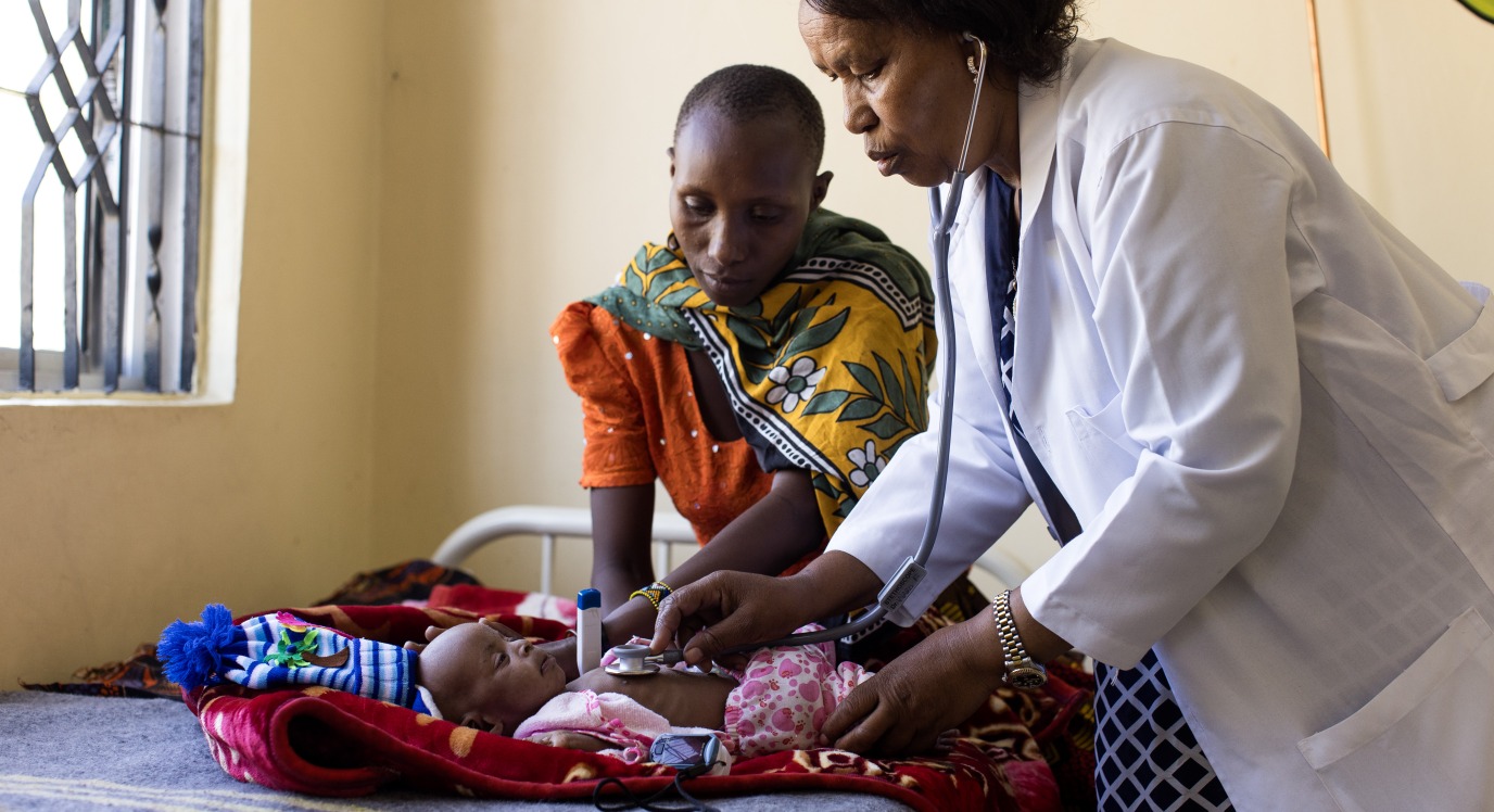 A doctor examines a child in a health center
