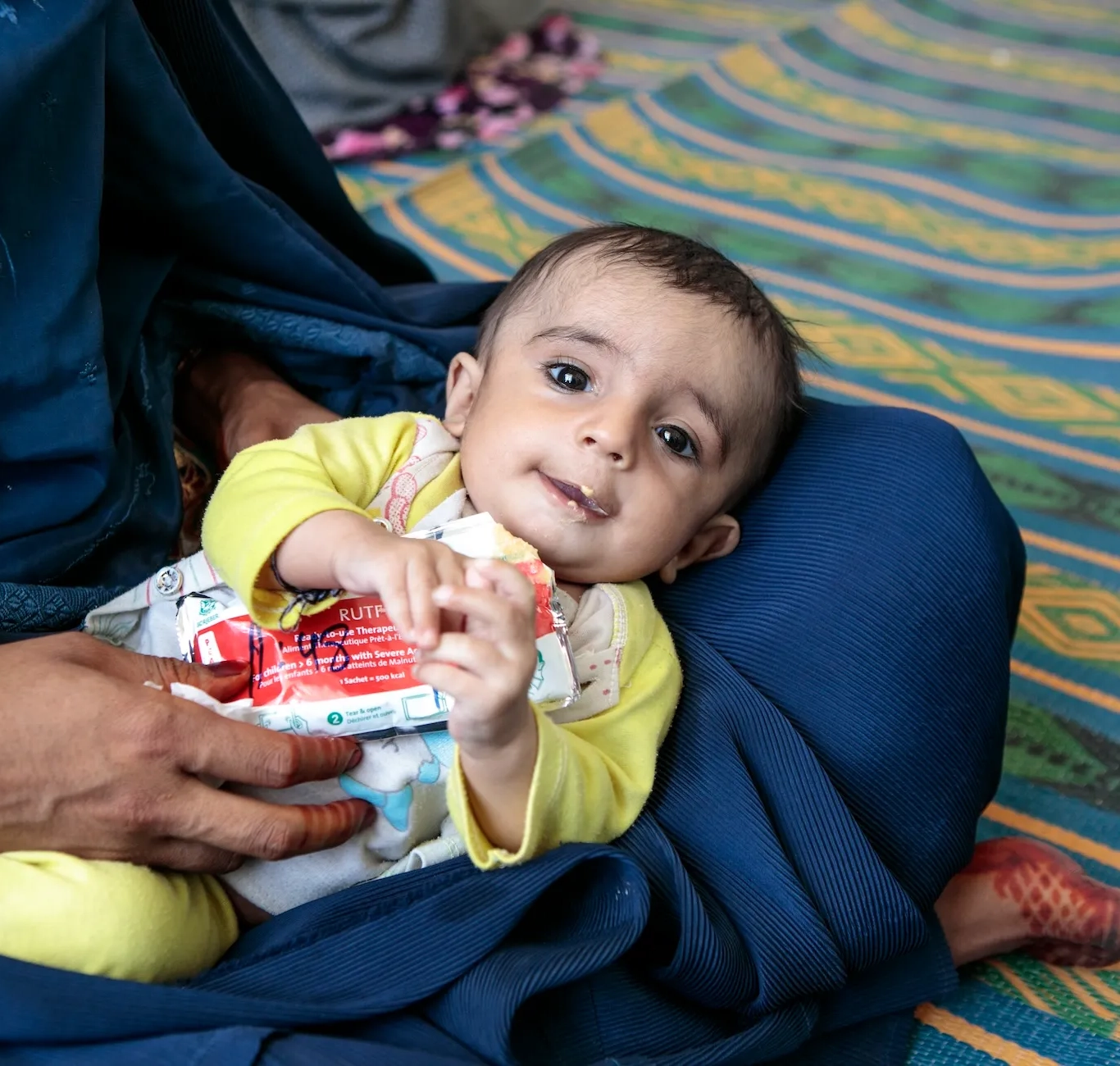 A child eats Plumpy'Nut, a peanut paste used to treat malnutrition.