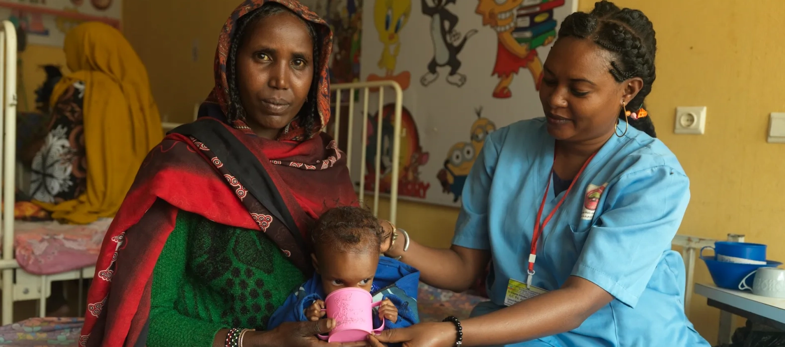 Action Against Hunger trained nurse Ware Arbale, 27, helps give therapeutic milk to baby Dabo who is suffering from severe malnutrition while mother Kebele looks on at the stabilisation centre in Yeblo General Hospital in Ethiopia.
