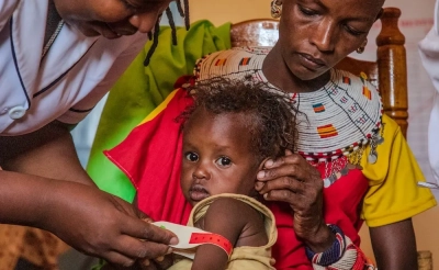 A child being screened for malnutrition by a health worker in Kenya.