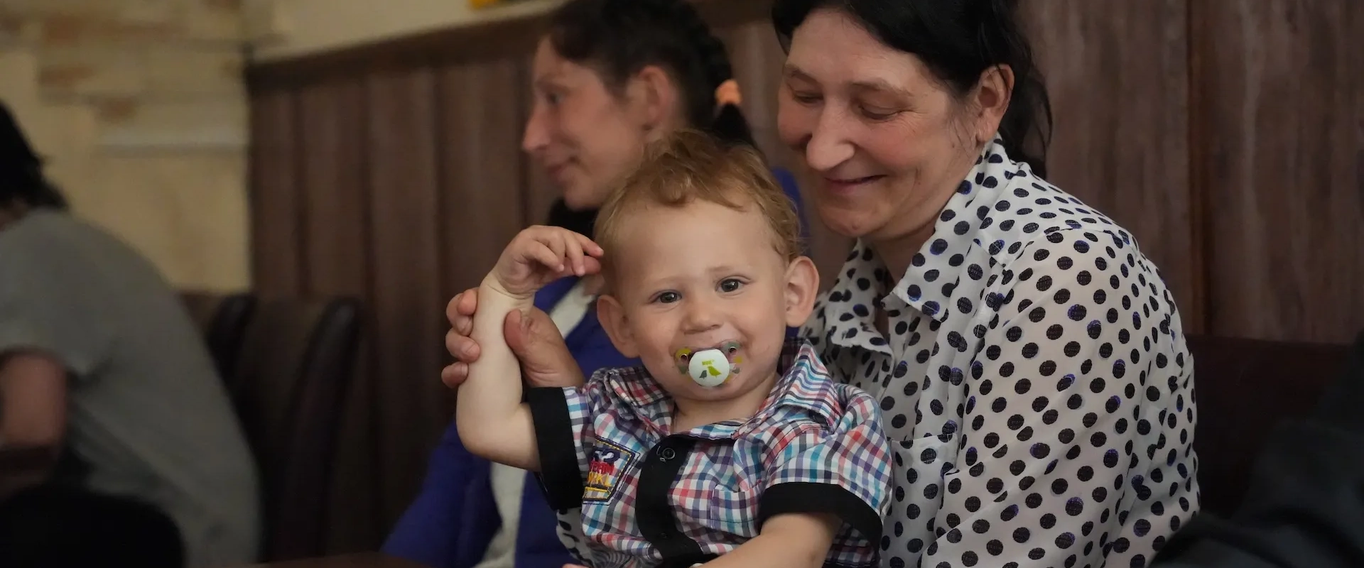 A woman holds a baby with a binky in his mouth in Dnipro, Ukraine.